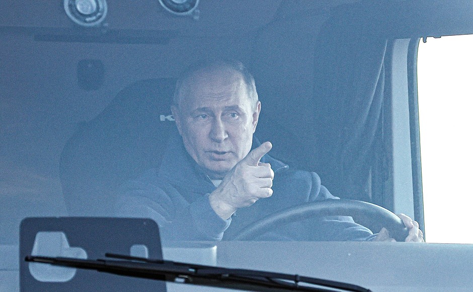 Vladimir Putin arriving at the M-12 Vostok Motorway road service facility behind the wheel of a KamAz truck.