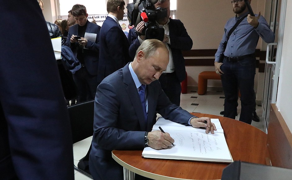 Vladimir Putin signs the distinguished visitors’ book at the Solchenchy Gorod (Sunny City) Children’s Creative Academy.