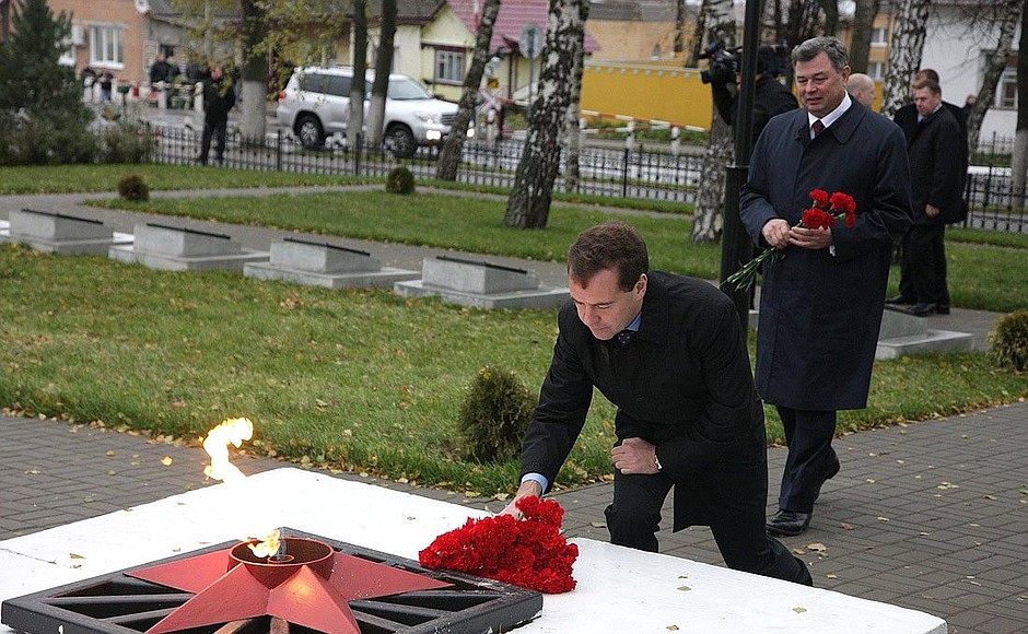Laying flowers at the Memorial to the Heroes of Kozelsk.