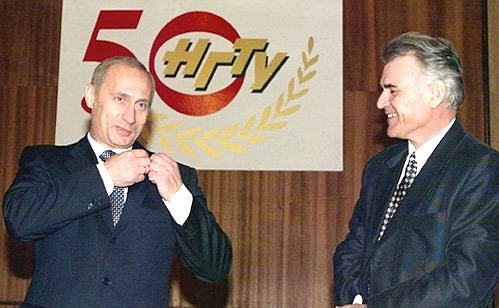 Rector of the university Anatoly Vostrikov presenting a badge in commemoration of the 50th anniversary of the university to President Vladimir Putin.