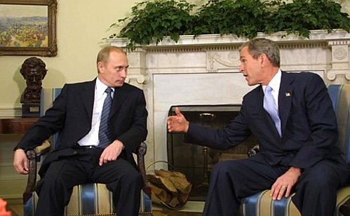 C. President Vladimir Putin and US President George W. Bush talking in the Oval Office.