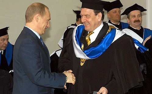 German Federal Chancellor Gerhard Schroeder being awarded the gown of St Petersburg State University\'s honourary doctor of law.