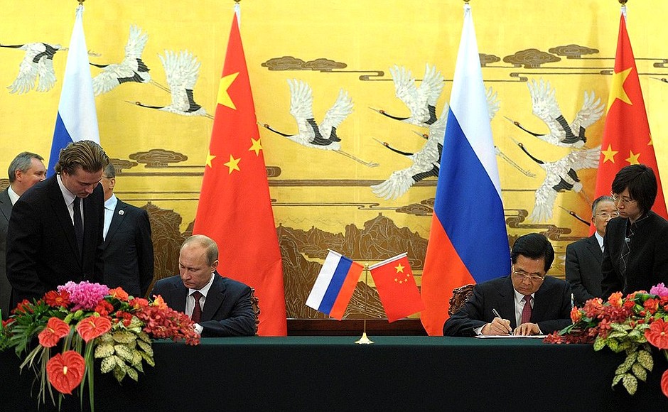 Signing documents following Russian-Chinese talks.