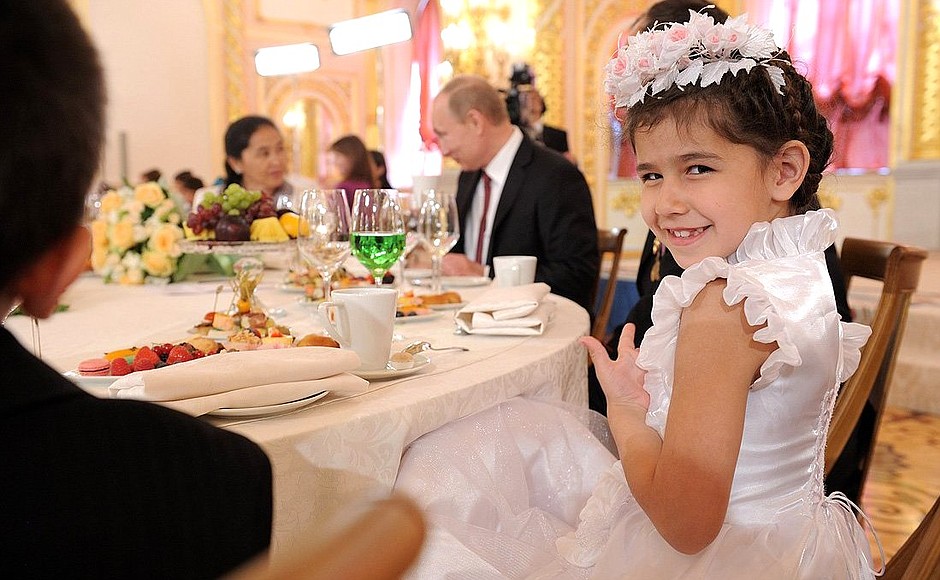 Vladimir Putin at the table with the family of Gulnara and Anatoly Bely, who are raising 8 children.