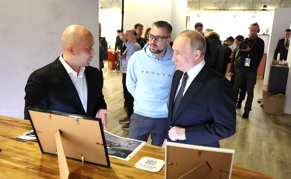 President Vladimir Putin, Rafael Khabirov, CEO of Mobitruck, left, and Mikhail Khomich, Special Projects Director of the ASI Operations Unit, at the Rising Russian Brands Contest exhibition.