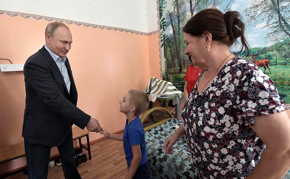 Vladimir Putin talking with the Safronov family, who lost their home in the flood.