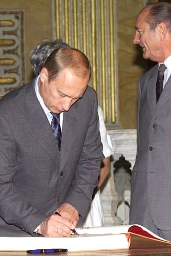 President Vladimir Putin making an entry in the distinguished visitors\' “Golden Book” of Genoa.