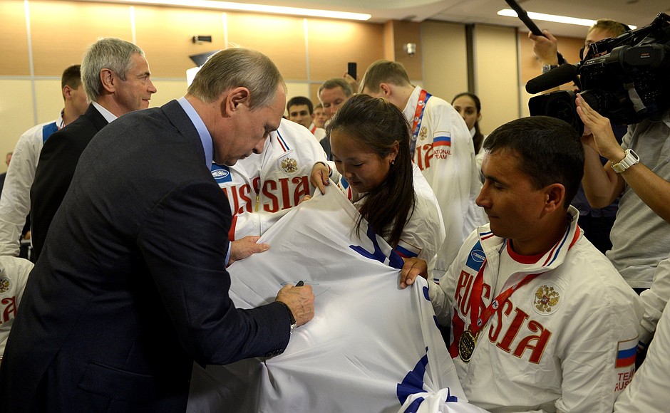 Владимир Путин оставил автограф на флаге Международной спортивной федерации IWAS.