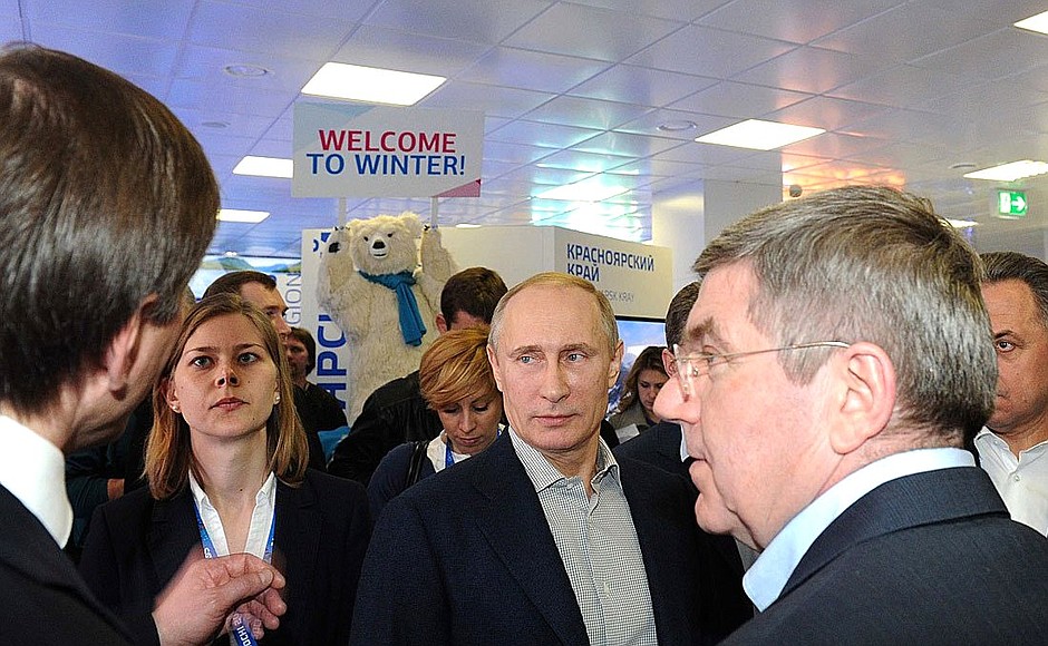 На экспозиции регионов Российской Федерации в Олимпийском парке.	С президентом Международного олимпийского комитета Томасом Бахом (справа).