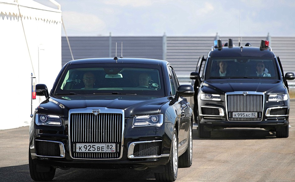 Vladimir Putin drives an Aurus limousine along a newly built section of the Taurida motorway.