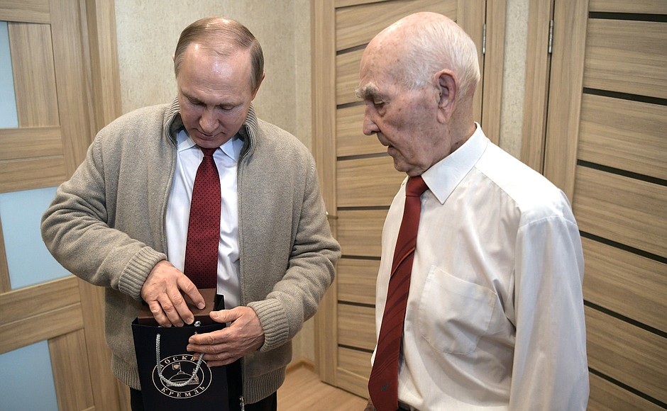 Vladimir Putin gives Lazar Matveyev a presidential watch and a copy of Pravda newspaper published on Mr Matveyev’s date of birth in 1927.