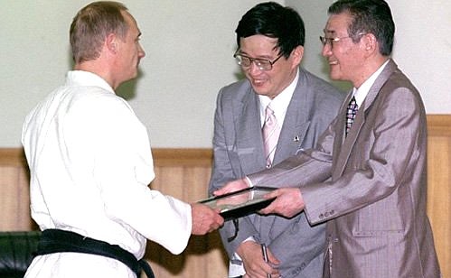 President Putin receiving a diploma and the 6th dan at the Kodokan Martial Arts Palace.