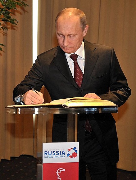 At the opening of the Hannover Messe 2013. Vladimir Putin signs the distinguished visitors’ book.