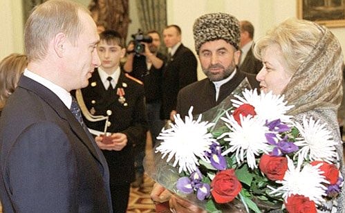 Members of the Chechen family of Tashukhadzhiyevs being decorated for their heroic behaviour in a clash with criminals. President Putin with Raisa Tashikhadzhiyeva.