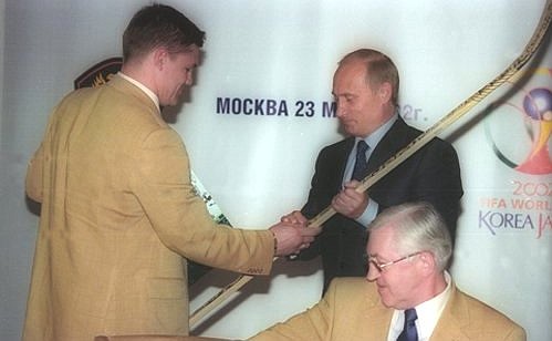 President Putin meeting with the players of the Russian football and ice hockey teams. Andrei Kovalenko, forward of the Russian ice hockey team, presenting President Putin with a hockey stick with autographs of the team\'s players.