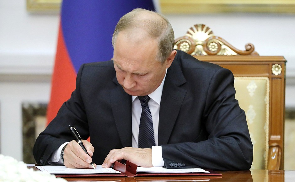 Signing documents following Russia-Turkmenistan talks.