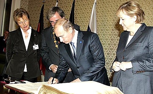 President Vladimir Putin and German Chancellor Angela Merkel signing the guests\' book.