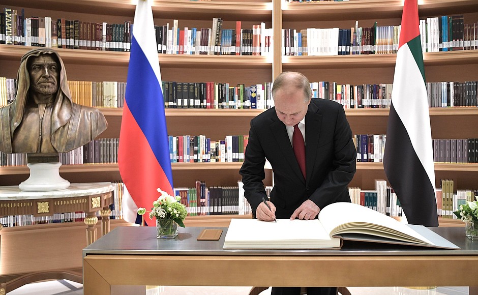Vladimir Putin signs the distinguished visitors’ book at the presidential library of the Qasr Al Watan Palace.