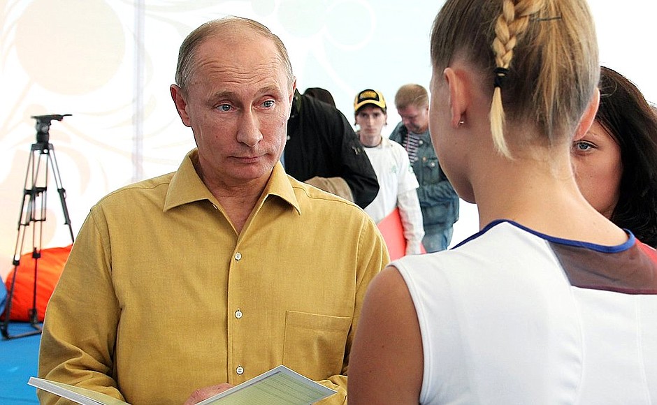 Vladimir Putin familiarizes himself with the projects of the participants at the Seliger 2013 Civil Youth Forum.