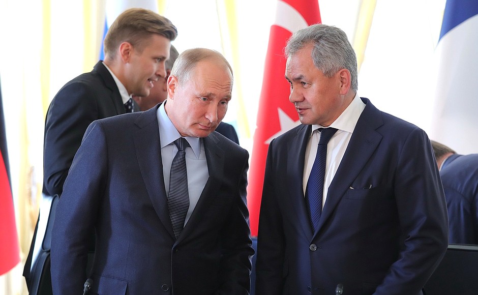 With Russian Defence Minister Sergei Shoigu before the meeting of the leaders of Russia, Turkey, Germany and France.