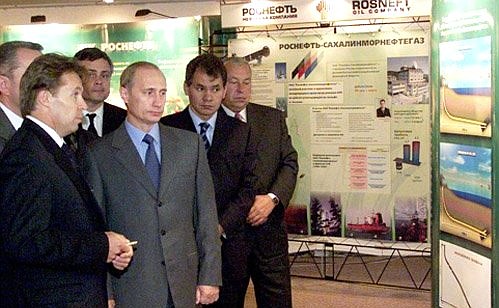 Vladimir Putin examining a display with Rosneft President Sergei Bogdanchikov and Emergencies Minister Sergei Shoigu.