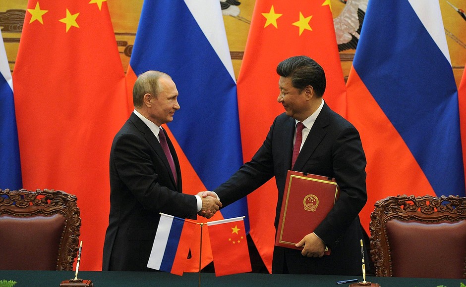 Signing documents following Russian-Chinese talks.