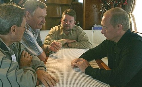 President Putin talking with scientists during a boat trip around the preserve.