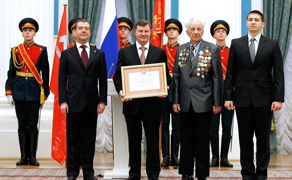 The certificate conferring the City of Military Glory title on Taganrog is presented to Mayor of Taganrog Nikolai Fedyanin, Great Patriotic War veteran Vladimir Borunov, and Taganrog State Pedagogical Institute student Alexander Lapshin.