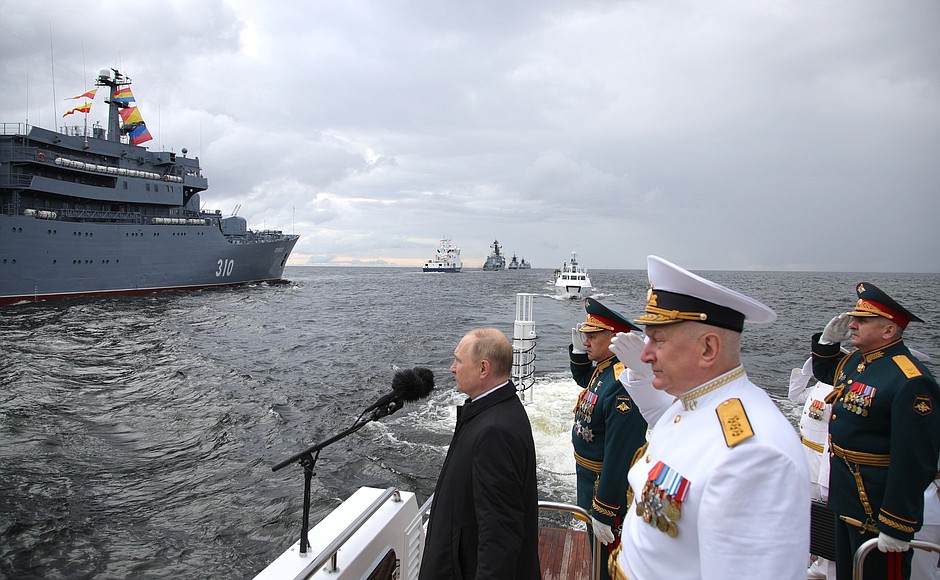 Before the beginning of the central part of the Main Naval Parade the Supreme Commander-in-Chief made the rounds of a parade line of military ships in the Kronstadt Yard and saluted the crews from the deck of a naval cutter. With Defence Minister Sergei Shoigu, Commander-in-Chief of the Russian Navy Nikolai Yevmenov and Acting Commander of the Western Military District Forces Vladimir Kochetkov.