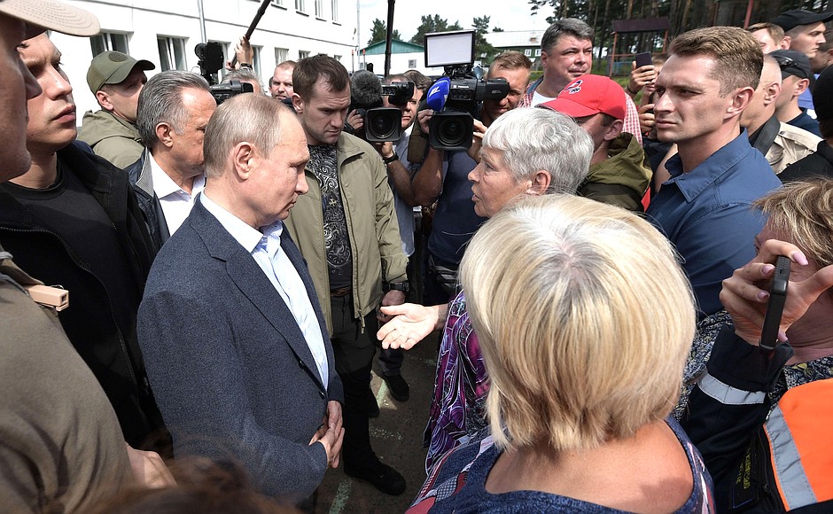 У входа в пункт временного размещения Владимир Путин встретился с пострадавшими и волонтёрами, которые помогают ликвидировать последствия наводнения.