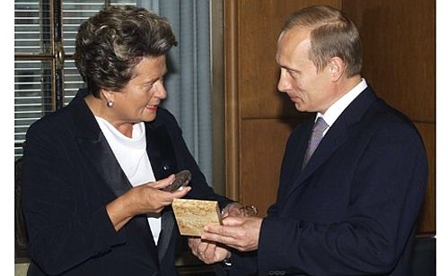 The speaker of the Finnish Parliament, Riitta Uosukainen, awarding a commemorative medal to President Putin.