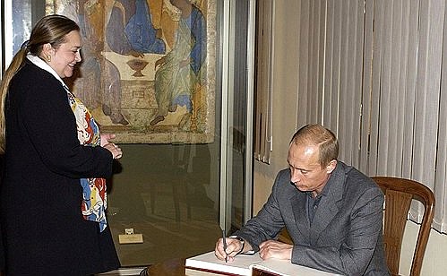 Владимир Путин оставил запись в книге почетных гостей Третьяковской галереи. Слева – главный хранитель музея Екатерина Селезнева.