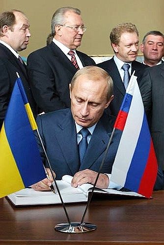 President Putin making an entry in the distinguished visitors\' book at the Dnieper hydroelectric plant.