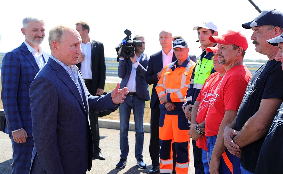 Vladimir Putin speaks with VAD workers who helped build the Taurida motorway.
