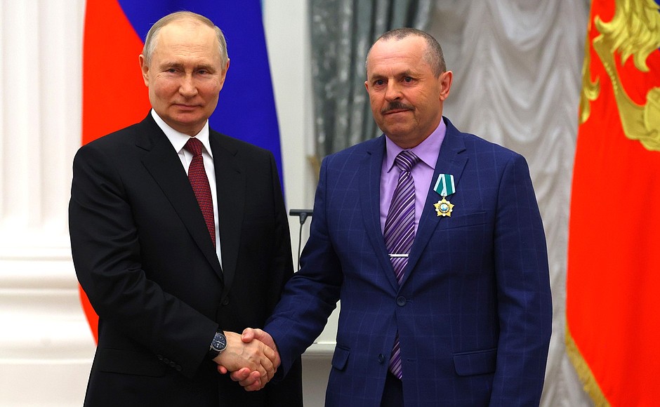 Ceremony for presenting state decorations. The Order of Friendship is awarded to Alexei Savelyev, a tractor driver at the agricultural farm Oktyabrskoye, Altai Territory.