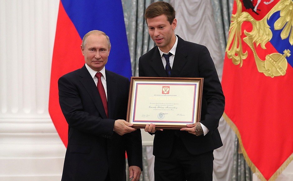 A letter of recognition for contribution to the development of Russia football and high athletic achievement is presented to Russia national football team player Fyodor Smolov.