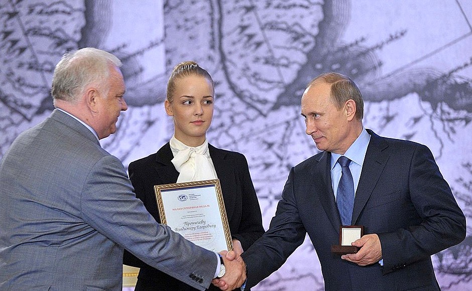 The small silver medal is awarded to Vladimir Pronichev, member of the Russian Geographical Society’s Board of Trustees, for his contribution to developing the society’s library.