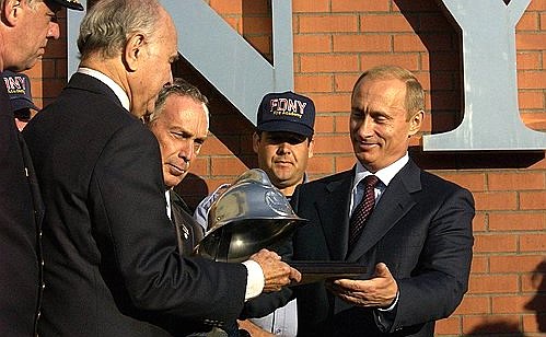President Putin presenting an antique fireman\'s helmet to the Academy of Fire Science.