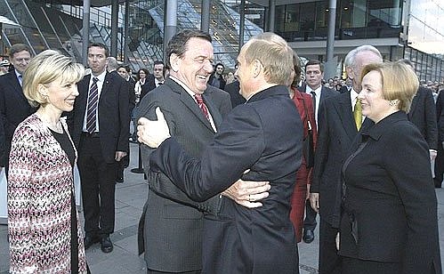 President Putin wishing German Chancellor Gerhard Schroeder a happy birthday. The wife of the Federal Chancellor, Doris Schroeder Koepf, left, and the wife of the Russian President, Lyudmila Putin, right.