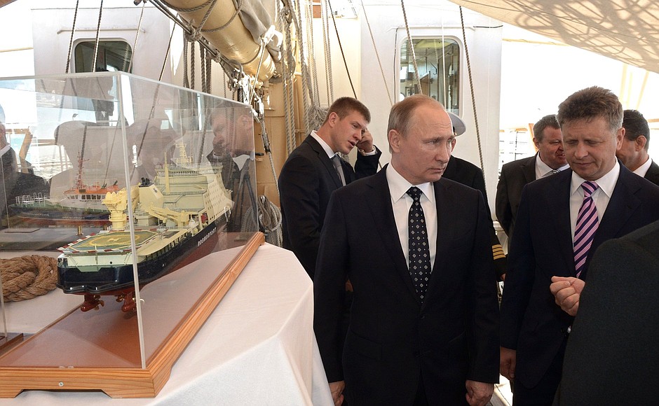 While aboard the Nadezhda tall ship, Vladimir Putin viewed Rosmorport and Sovkomflot cargo ship models. Right: Transport Minister Maxim Sokolov.