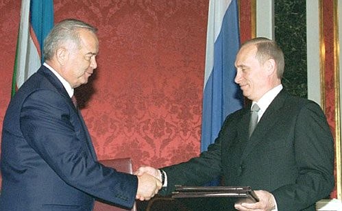 President Putin and Uzbek President Islam Karimov signing joint documents.