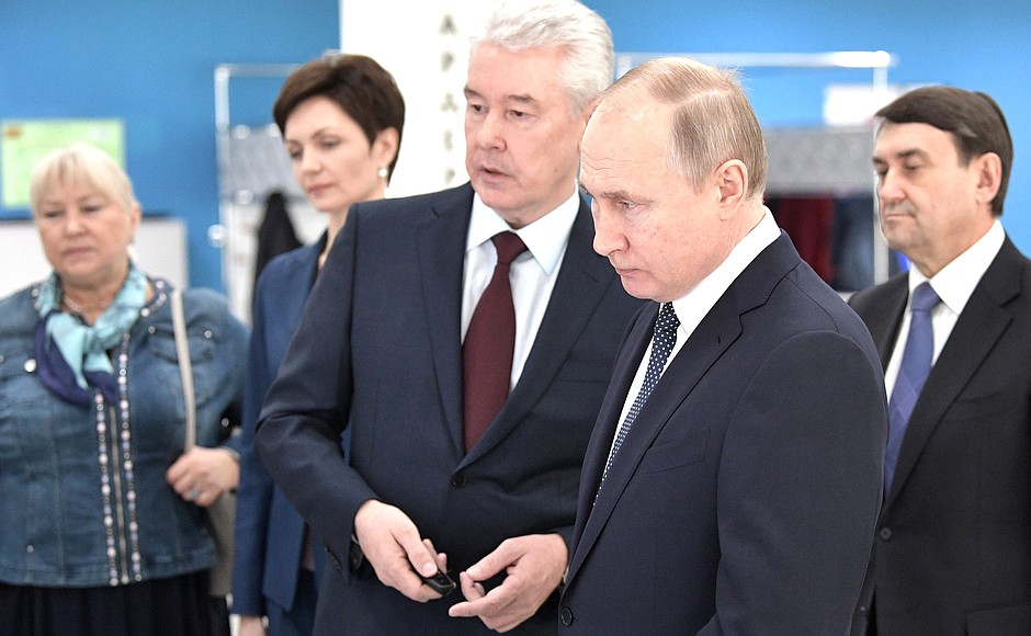 At the Olympic Synchronised Swimming Centre of Anastasia Davydova. Vladimir Putin and Moscow Mayor Sergei Sobyanin examine the information stand on the development of physical culture and sport in Moscow.