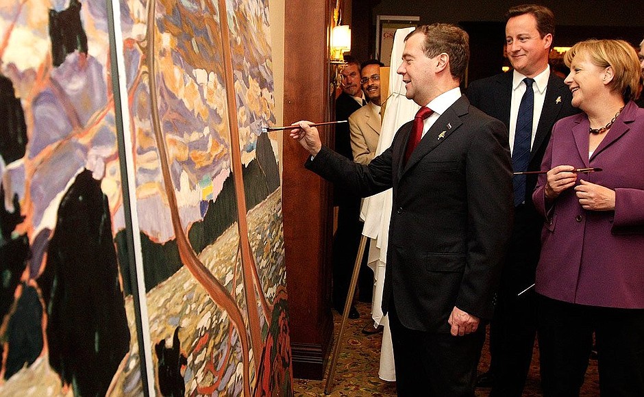 Following the meeting with Junior G8 representatives, Dmitry Medvedev and other summit participants symbolically completed a painting by local artist Gerry Lantaigne which will be donated to the city of Huntsville. With UK Prime Minister David Cameron and German Federal Chancellor Angela Merkel.