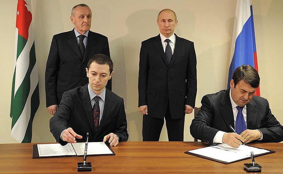 Vladimir Putin and President of Abkhazia Alexander Ankvab witness the signing by Acting Transport Minister of Russia Igor Levitin (right) and Minister of the Economy of Abkhazia David Iradyan of the Protocol to the Agreement between the Governments of Russia and Abkhazia on organising direct international railway service.
