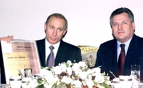 President Putin handing over copies of documents from Russian archives to Polish President Aleksander Kwasniewski.