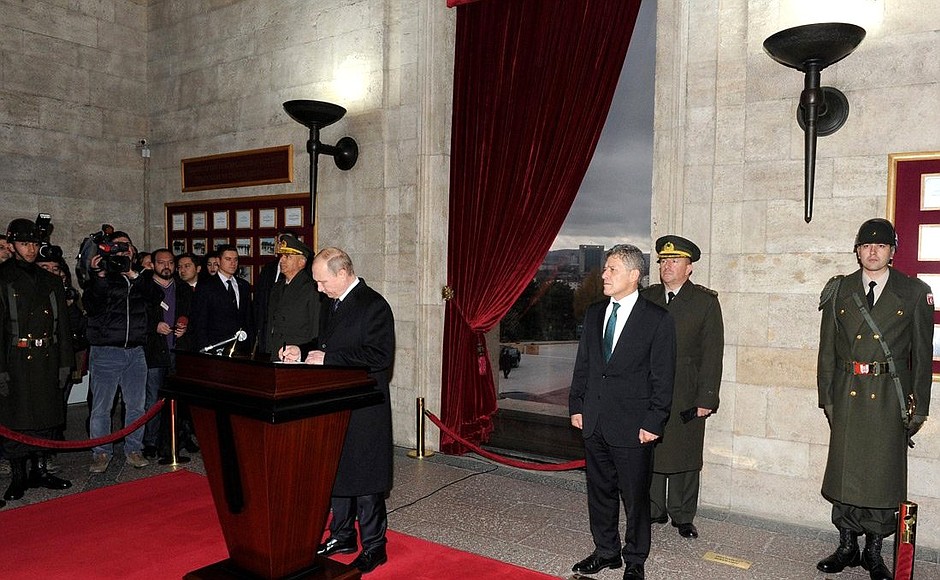 Vladimir Putin signs in the distinguished visitors’ book while visiting the mausoleum of Mustafa Kemal Ataturk.