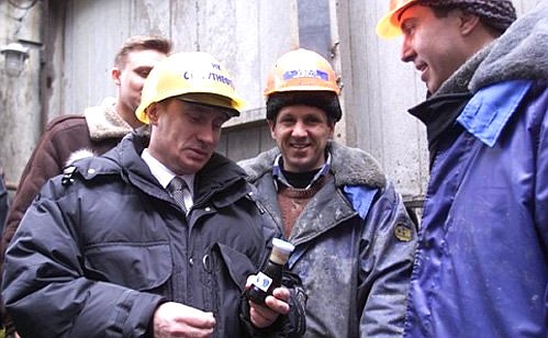 Vladimir Putin visiting an operating drilling tower near Surgut. A flask of Surgut oil is a workers\' gift.