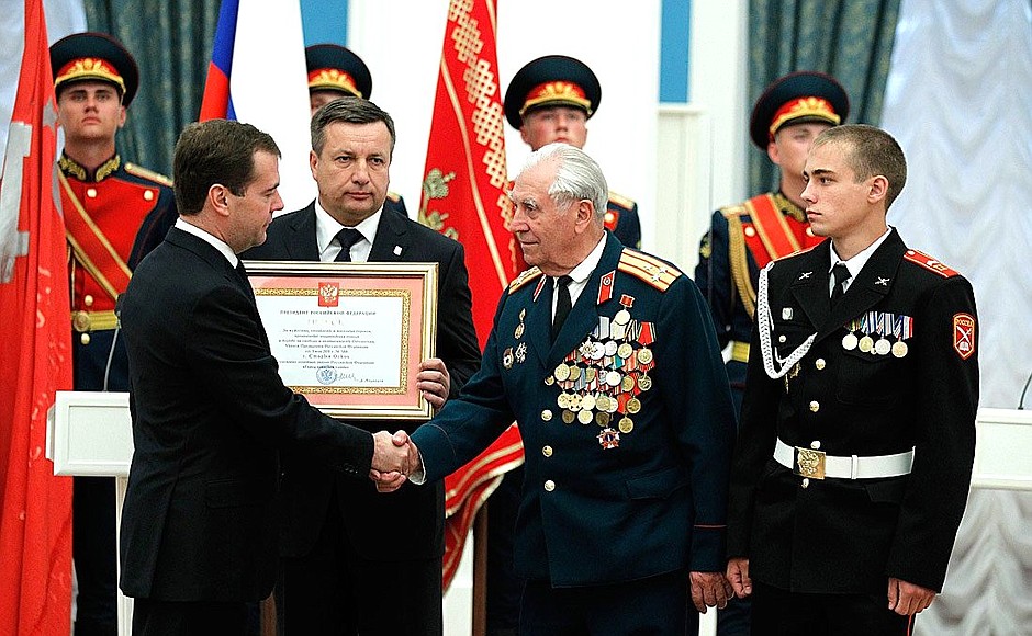Presenting the certificate conferring the title of City of Military Glory to representatives of the city of Stary Oskol.