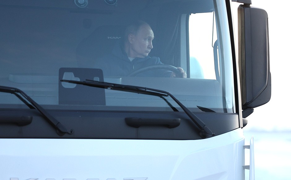 Vladimir Putin arriving at the M-12 Vostok Motorway road service facility behind the wheel of a KamAz truck.