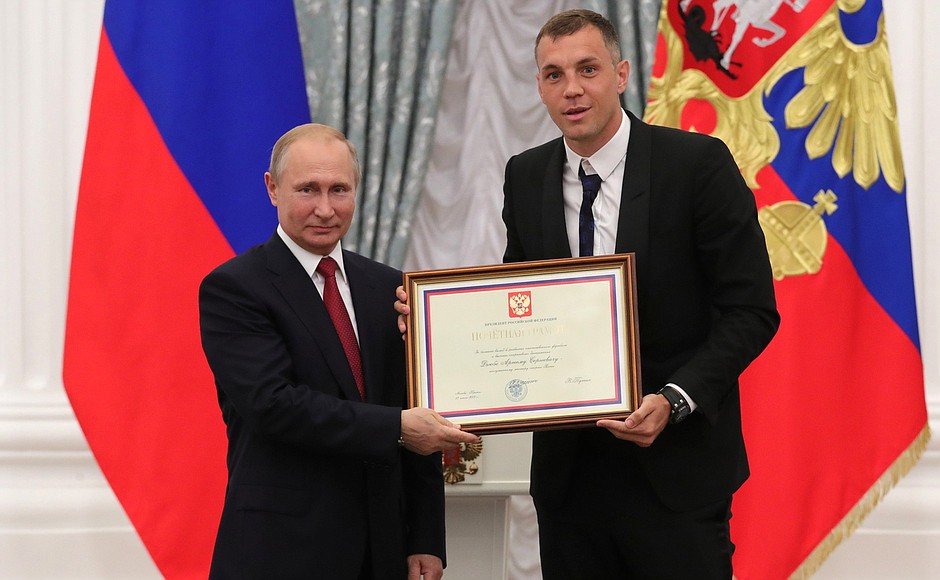A letter of recognition for contribution to the development of Russia football and high athletic achievement is presented to Russia national football team player Artyom Dzyuba.
